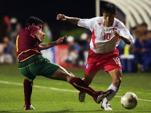 South Korea full-back Lee Young-pyo dribbles past Portugal winger Luis Figo on June 14, 2002.