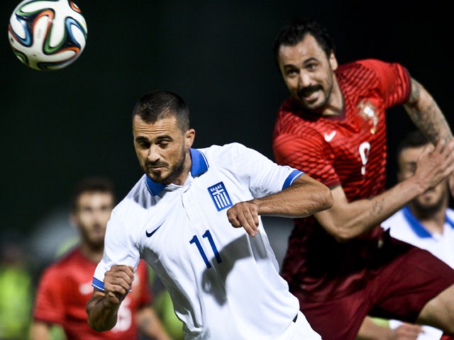 Portugal's forward Hugo Almeida vies with Greece's defender Loukas Vyntra (L) during the friendly football match Portugal vs Greece at the Jamor National stadium in Oeiras on the outskirts of Lisbon on May 31, 2014