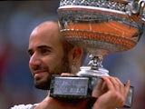 Andre Agassi of the United States celebrates victory with the trophy during the 1999 French Open Final match against Andrei Medvedev on June 6, 1999