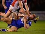 James Laithwaite of Warrington Wolves is tackled during the Super League match between Warrington Wolves and St Helens at The Halliwell Jones Stadium on February 13, 2014 