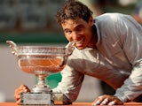 Rafael Nadal of Spain bites the Coupe de Mousquetaires after victory in his men's singles final match against Novak Djokovic on June 8, 2014