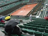 A tarpaulin covers the Philippe Chatrier court as the rain falls ahead of a French Open quarter final match at the Roland Garros, Paris on June 4, 2014
