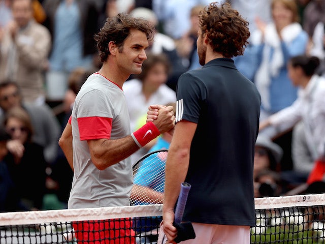 Roger Federer and Ernests Gulbis shake hands at the net after the latter's victory in the French Open on June 1, 2014