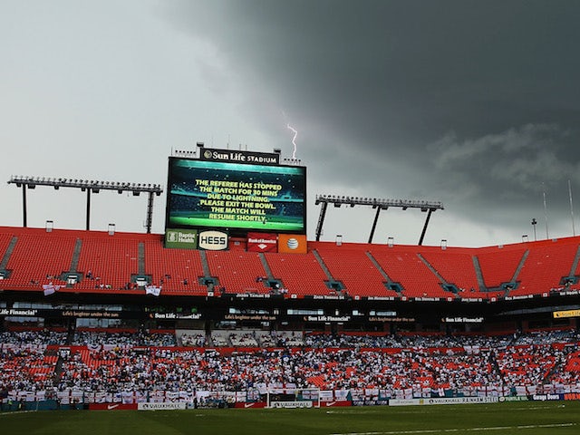 Lightning strikes behind the scoreboard as the match is delayed due to inclement weather during the International Friendly match between England and Honduras on June 7, 2014
