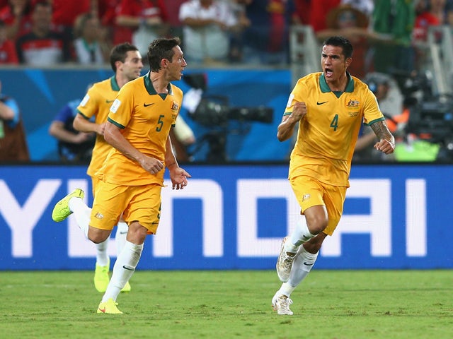 Tim Cahill of Australia celebrates scoring his teams first goal with teammate Mark Milligan during the 2014 FIFA World Cup Brazil Group B match between Chile and Australia at Arena Pantanal on June 13, 2014