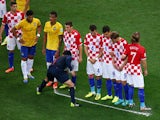 Referee Yuichi Nishimura sprays a temporary line on the field marking ten yards as players from Brazil and Croatia form a wall during the 2014 FIFA World Cup Brazil Group A match between Brazil and Croatia at Arena de Sao Paulo on June 12, 2014
