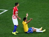 Fred of Brazil gestures for a foul from the ground as Dejan Lovren of Croatia looks on in the second half during the 2014 FIFA World Cup Brazil Group A match between Brazil and Croatia at Arena de Sao Paulo on June 12, 2014