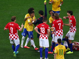 Neymar of Brazil is shown a yellow card by referee Yuichi Nishimura during the 2014 FIFA World Cup Brazil Group A match between Brazil and Croatia at Arena de Sao Paulo on June 12, 2014