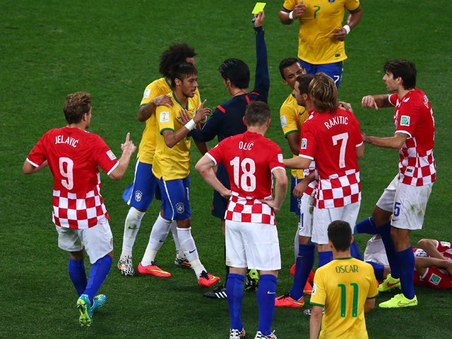 Neymar of Brazil is shown a yellow card by referee Yuichi Nishimura during the 2014 FIFA World Cup Brazil Group A match between Brazil and Croatia at Arena de Sao Paulo on June 12, 2014