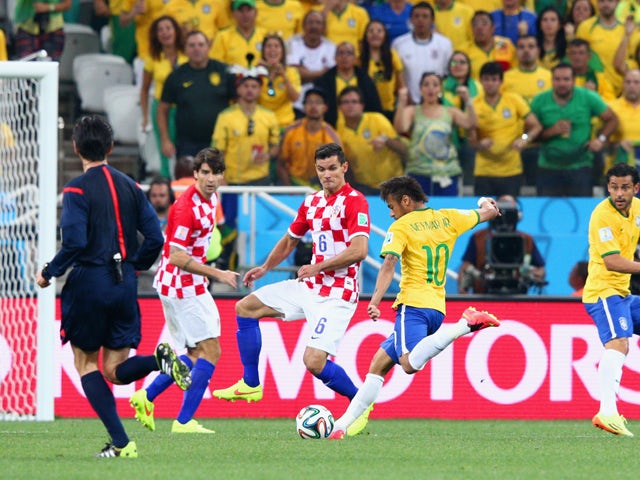 Neymar of Brazil shoots and scores against Dejan Lovren of Croatia in the first half during the 2014 FIFA World Cup Brazil Group A match between Brazil and Croatia at Arena de Sao Paulo on June 12, 2014
