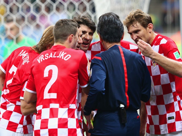 Referee Yuichi Nishimura is surrounded by Croatia players after awarding a penalty kick in the second half during the 2014 FIFA World Cup Brazil Group A match between Brazil and Croatia at Arena de Sao Paulo on June 12, 201