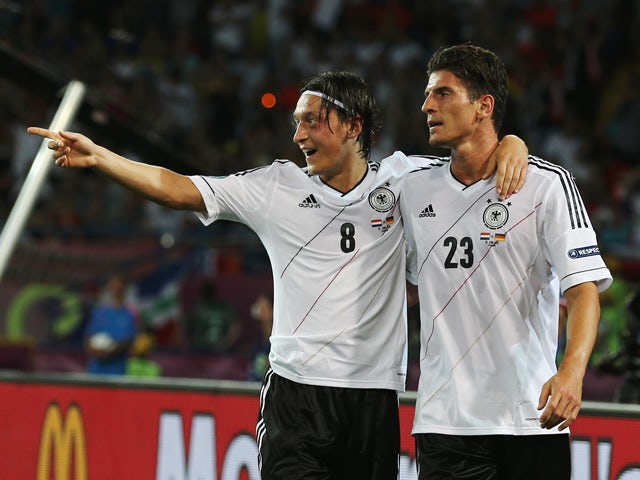 Mario Gomez of Germany celebrates scoring their second goal with Mesut Ozil of Germany during the UEFA EURO 2012 group B match between Netherlands and Germany at Metalist Stadium on June 13, 2012 