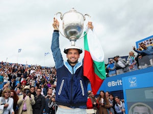 Bulgaria's Grigor Dimitrov celebrates with the winners trophy after clinching victory in the AEGON Championships at Queen's Club on June 15, 2014