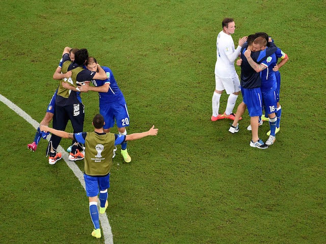 Wayne Rooney of England congratulates Italy as they celebrate their win during the 2014 FIFA World Cup Brazil Group D match at Arena Amazonia on June 14, 2014