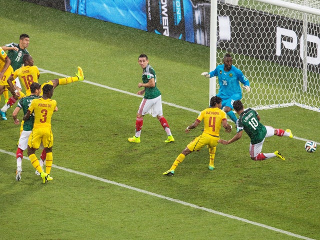 Giovani dos Santos of Mexico puts the ball in the net but the goal was disallowed due to an offsides call as Charles Itandje of Cameroon looks on in the first half during the 2014 FIFA World Cup Brazil Group A match between Mexico and Cameroon at Estadio 