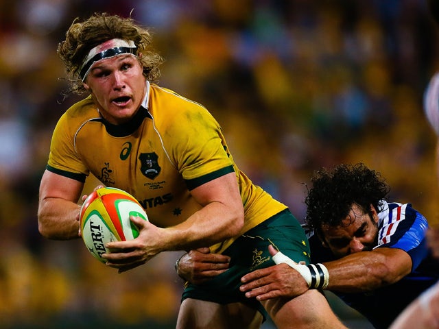 Australian flanker Michael Hooper is tackled by French wing Yoann Huget during the first rugby union test match against France at Suncorp Stadium in Brisbane on June 7, 2014