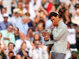 Rafael Nadal of Spain wipes tears away from his eyes as he celebrates with the Coupe de Mousquetaires after victory in his men's singles final match against Novak Djokovic at the French Open on June 8, 2014