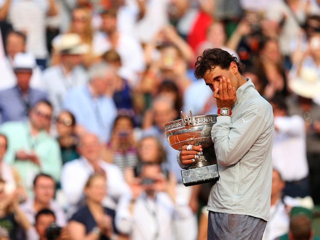 Rafael Nadal of Spain wipes tears away from his eyes as he celebrates with the Coupe de Mousquetaires after victory in his men's singles final match against Novak Djokovic at the French Open on June 8, 2014