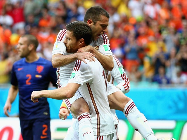  Jordi Alba of Spain jumps on teammate Xabi Alonso in celebration after a goal on a penalty kick by Alonso in the first half during the 2014 FIFA World Cup Brazil Group B match between Spain and Netherlands at Arena Fonte Nova on June 13, 2014