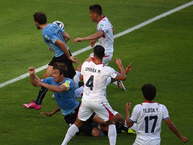 Uruguay's defender Diego Lugano falls after being brought down by Costa Rica's defender Junior Diaz during a Group D football match between Uruguay and Costa Rica at the Castelao Stadium in Fortaleza during the 2014 FIFA World Cup on June 14, 2014
