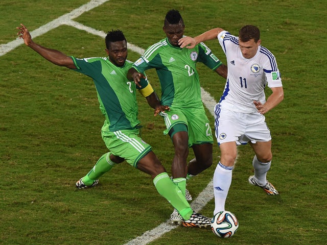 Bosnia-Hercegovina's forward Edin Dzeko fights for the ball with Nigeria's defender Joseph Yobo and Nigeria's defender Kenneth Omeruo during the Group F football match between Nigeria and Bosnia-Hercegovina at the Pantanal Arena in Cuiaba during the 2014 