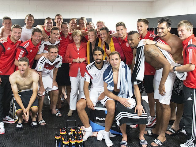 German Chancellor Angela Merkel visits the German National team in their dressing room after the 2014 FIFA World Cup Group G match against Portugal at Arena Fonte Nova on June 16, 2014 in Salvador, Brazil