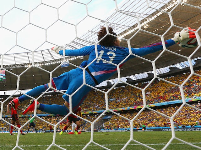 Mexico goalkeeper Guillermo Ocha dives at full stretch to make a save during the World Cup Group A match in Fortaleza against Brazil on June 17, 2014