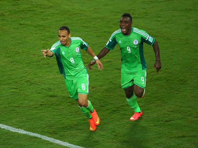 Peter Odemwingie of Nigeria celebrates scoring his team's first goal with teammate Emmanuel Emenike during the 2014 FIFA World Cup Group F match between Nigeria and Bosnia-Herzegovina at Arena Pantanal on June 21, 2014