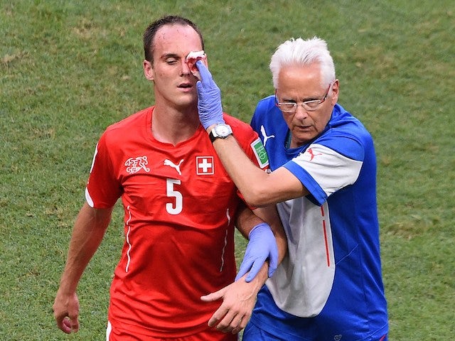 Switzerland's defender Steve von Bergen (L) receives medical assistance after being injured during a Group E football match against France on June 20, 2014