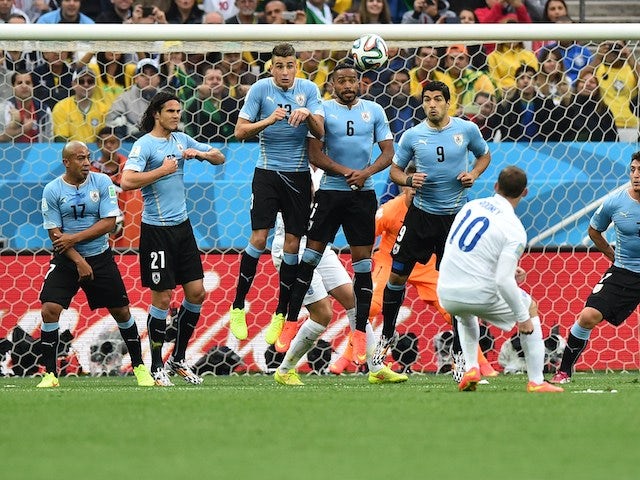 England's forward Wayne Rooney (2R) takes a free-kick past Uruguayan defenders during the Group D football match between Uruguay and England at the Corinthians Arena in Sao Paulo on June 19, 2014