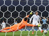 England's forward Wayne Rooney (L) scores against Uruguay's goalkeeper Fernando Muslera (L) during a Group D football match on June 19, 2014