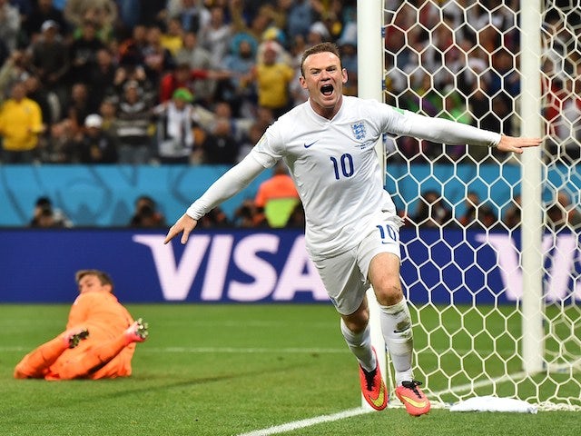 England's forward Wayne Rooney (R) celebrates after scoring past Uruguay's goalkeeper Fernando Muslera during the Group D football match on June 19, 2014