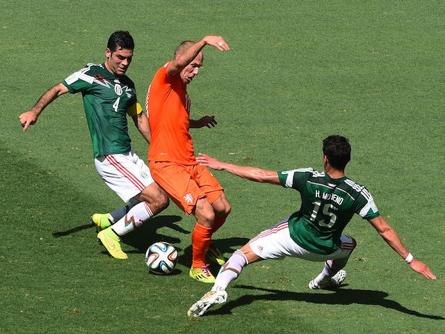 Netherlands winger Arjen Robben is tackled by Mexico duo Hector Moreno and Rafael Marquez during the World Cup last-16 tie in Fortaleza on June 29, 2014