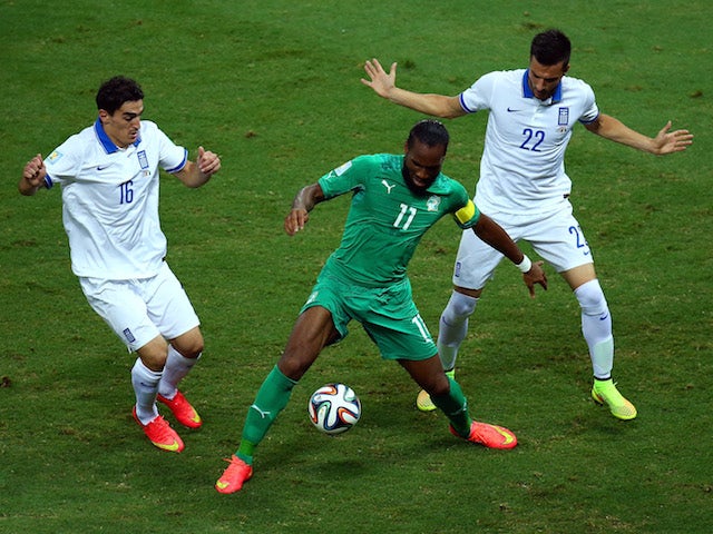 Didier Drogba of the Ivory Coast is challenged by Lazaros Christodoulopoulos (L) and Andreas Samaris of Greece during the 2014 FIFA World Cup Brazil Group C match on June 24, 2014