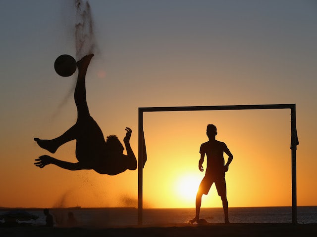 Locals play football at the Iracemar beach on June 22, 2014 in Fortaleza, Brazil