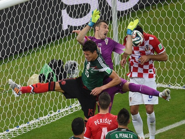 Mexico's defender Hector Moreno and Croatia's goalkeeper Stipe Pletikosa clash during a Group A football match on June 23, 2014