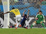 Colombia's forward Jackson Martinez (L) strikes to score a goal as Japan's goalkeeper Eiji Kawashima defends during the Group C football match on June 24, 2014
