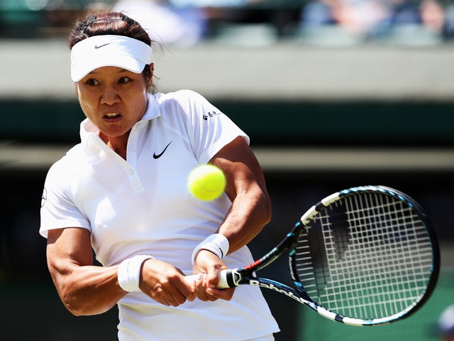 Li Na of China plays a backhand return during the Ladies' Singles third round match Barbora Zahlavova Strycova of Czech Republic on day five of the Wimbledon Lawn Tennis Championships at the All England Lawn Tennis and Croquet Club on June 27, 2014
