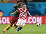 Croatia's midfielder Luka Modric is tackled by Cameroon's forward Benjamin Moukandjo during the Group A football match between Cameroon and Croatia at The Amazonia Arena in Manaus on June 18, 2014