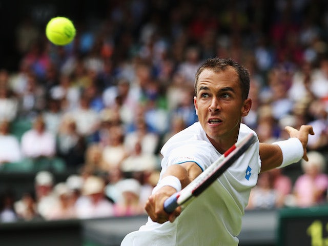 Lukas Rosol of Czech Republic hits a backhand return during his Gentlemen's Singles second round match against Rafael Nadal on June 26, 2014