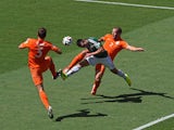 Hector Herrera of Mexico goes for a header against Stefan de Vrij (L) and Ron Vlaar of the Netherlands during the 2014 FIFA World Cup round of 16 match in Fortaleza on June 29, 2014