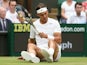 Spain's Rafael Nadal sits on the grass after slipping against Kazakhstan's Mikhail Kukushkin during their men's singles third round match on June 28, 2014