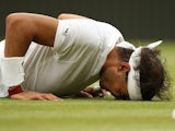 Spain's Rafael Nadal lies on the court after slipping during a point in his men's singles third round match against Kazakhstan's Mikhail on June 28, 2014