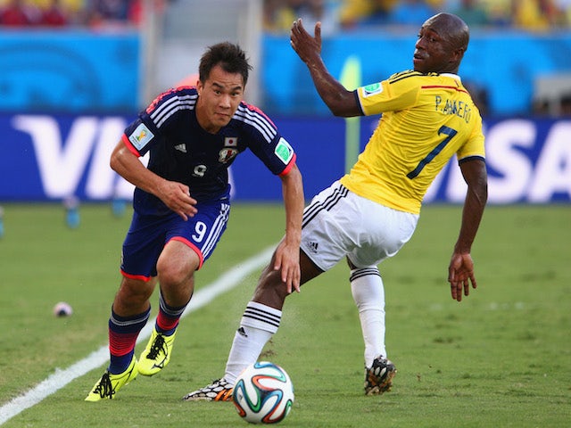 Shinji Okazaki of Japan driblbles past Pablo Armero of Colombia during the 2014 FIFA World Cup Brazil Group C match between Japan and Colombia at Arena Pantanal on June 24, 2014