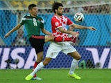 Croatia's defender Vedran Corluka (R) and Mexico's forward Oribe Peralta vie for the ball during a Group A football match on June 23, 2014