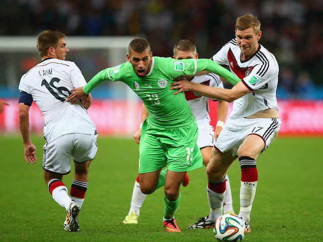 Islam Slimani of Algeria is challenged by Philipp Lahm (L) and Per Mertesacker of Germany during the 2014 FIFA World Cup on June 30, 2014