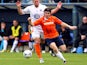 Luke Rooney of Luton Town goes past Matt Paine of Braintree Town during the Skrill Conference Premier match between Luton Town and Braintree Town at Kenilworth Road on April 12, 2014
