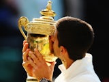 Serbia's Novak Djokovic celebrates with the trophy after winning Wimbledon on July 6, 2014