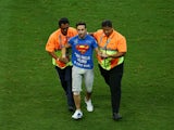  A pitch invader is taken off the field by security during the 2014 FIFA World Cup Brazil Round of 16 match between Belgium and the United States at Arena Fonte Nova on July 1, 2014