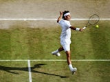 Swiss tennis player Roger Federer plays a backhand volley during his Wimbledon semi-final against Milos Raonic on July 6, 2014